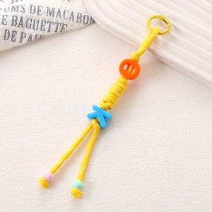 Détail d'un porte-clés tressé jaune fait main avec perles lettres OK colorées