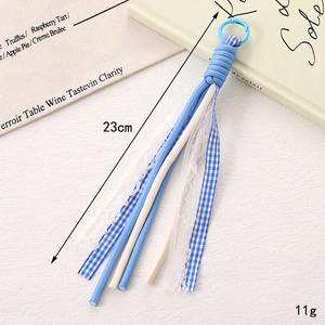 Détail du bijou de sac tressé bleu à carreaux et dentelle, long 23cm et pesant 11g