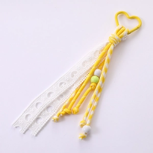 Handmade heart ribbon bag charm with yellow metal ring and white lace ribbon design