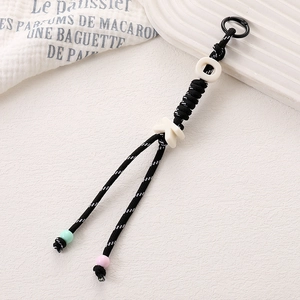 Détail du pendentif tissé main avec perles de lettres et petites perles de finition
