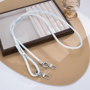 Detail of light blue woven phone strap with silver metal lobster clasps on a tray