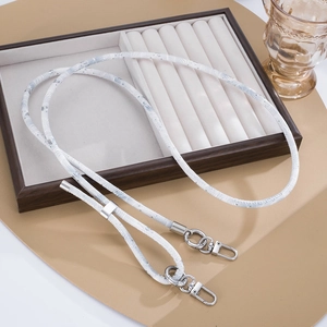 Detailed view of the woven heart pattern lanyard with silver metal lobster clasps