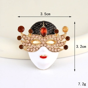 Detail view of a vintage mask charm with red rhinestones and white enamel finish