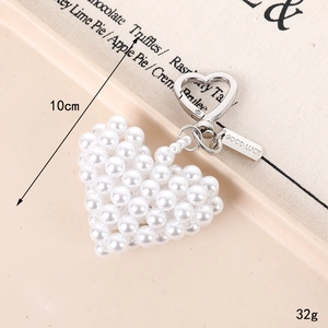 Handmade heart-shaped pearl bag charm with a silver Good Luck tag and metal clasp