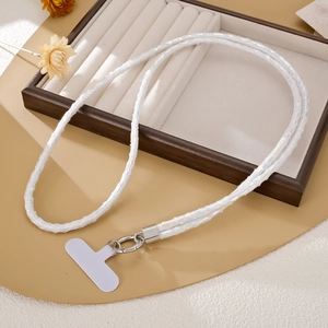 Detailed view of white sequined phone lanyard with silver clasp on a velvet tray