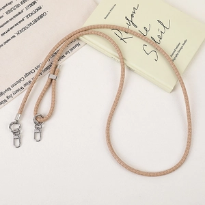 Close-up of beige woven PU leather lanyard with silver metal lobster clasps for bags