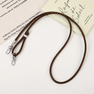 Detail of adjustable dark brown braided leather phone strap with silver metal lobster clasp