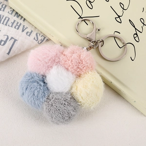 Macro detail of the soft plush flower keychain with colorful pom poms and silver lobster clasp