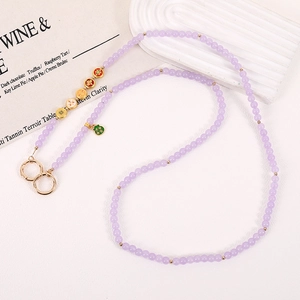 Detail of light purple beaded phone strap with green Fu character and gold clasp