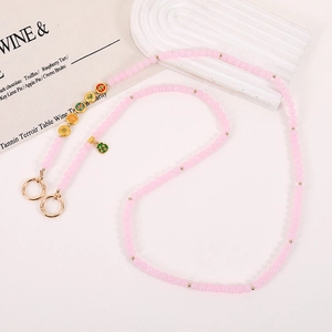 Detail of pink glass beads phone strap with enamel charms and green gourd pendant