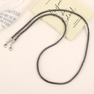 Gunmetal bead crossbody chain with silver lobster clasps on aesthetic book background