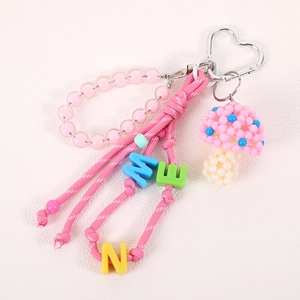Handmade beaded pink mushroom keychain with letter beads and a heart-shaped metal clasp