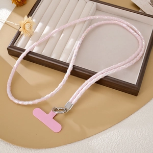 Détail du cordon de téléphone en peluche rose avec anneau en métal et carte de fixation
