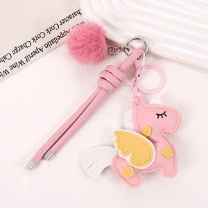 Detailed view of pink faux leather unicorn charm with white pompom and silver metal clasp