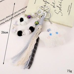 Detailed view of plush star keychain with faux pearls, lace ribbons, and heart carabiner