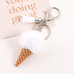 Detailed macro view of plush white fur ball ice cream keychain with silver clasp