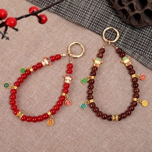 Retro Chinese style beaded phone charms with mascot pendants and festive red accents