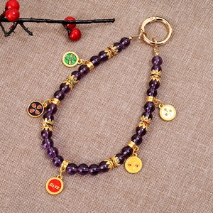 Detail of purple beaded phone charm with five colorful wealth god pendants and gold clasp