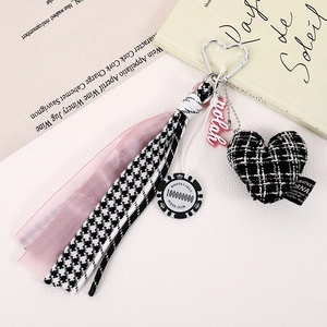 Detail of heart houndstooth charm with poker chip and pink silk tassel keychain
