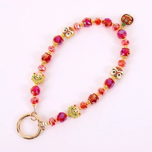 Beaded clover and lion phone charm with red crystals and golden spring clasp