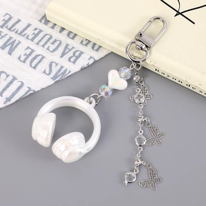 Detail of white headphone keychain with rainbow heart beads and silver butterfly charm