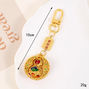 Detail of golden hollow gourd keychain with colorful enamel and engraved safety charm