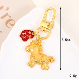 Dettaglio portachiavi a forma di cavallo dorato lungo 6,5 cm con piccolo ciondolo rosso