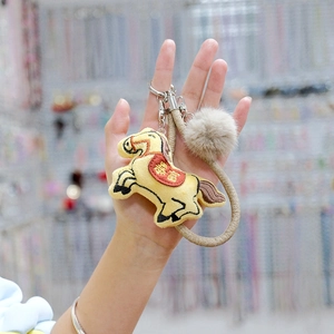 Cute yellow plush horse keychain with rich embroidery and fuzzy pompom accessory