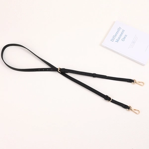 Adjustable black faux leather purse strap with gold lobster clasps and polished hardware