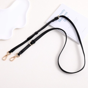 Adjustable black lychee leather bag strap with golden buckles and metal ring detail