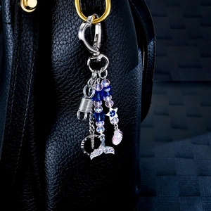 Star and shell pendant keychain with beads on black leather bag