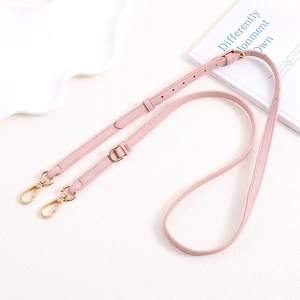 Close-up of pink litchi grain leather strap with adjustable gold metal buckles