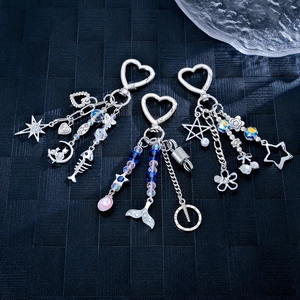 Three Korean-style shell fish tail and flower charms with silver heart-shaped clasps