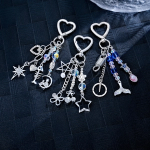 Silver alloy fishtail and shell charms with pearls and stars on dark texture