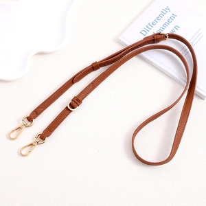 Detail of adjustable brown pebble leather strap with gold lobster clasps and D-ring