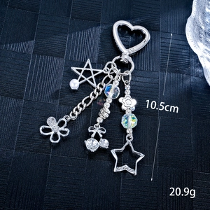 Star and pearl keychain with heart clasp, floral cherry charms on blue texture