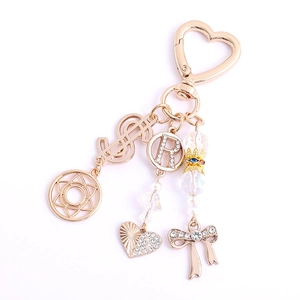 Portachiavi dorato con chiusura a cuore, segno del dollaro e ciondoli con cuore di strass