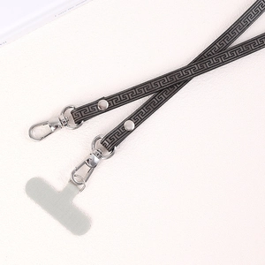 Detail view of woven phone strap with gray Greek Key pattern and silver metal lobster clasps