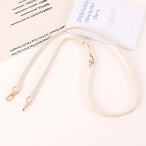 Dettaglio tracolla regolabile in pelle beige chiaro con moschettoni in oro lucido