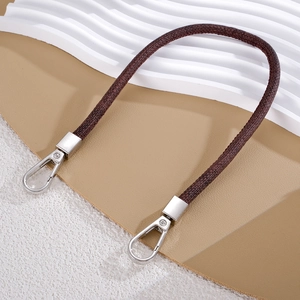 Detail of dark brown textured leather strap with polished silver metal lobster clasps