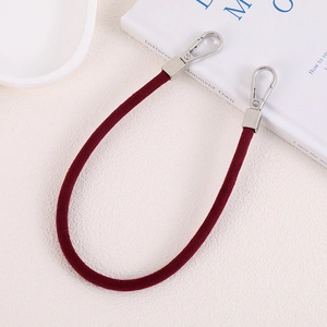 Detail of burgundy suede wristlet strap with silver metal lobster clasps on each end