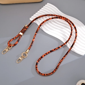Detail eines verstellbaren Lederriemens mit Leopardenmuster und goldenem Karabiner