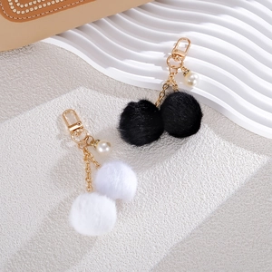 Chic double pom pom keychain with faux pearls and gold chain in black and white styles