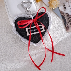 Lace-trimmed denim heart bag charm with ribbon bow and metal clasp on aesthetic background