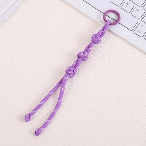 Detailed macro view of purple hand-woven nylon paracord bag charm with a spring buckle