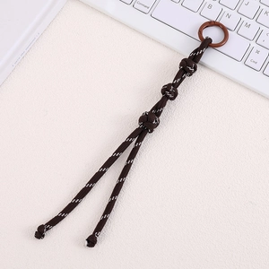 Detail of dark brown braided nylon bag charm with decorative knots and spring buckle