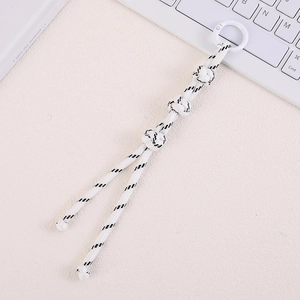 Macro shot of white hand-woven nylon bag charm with decorative knots and spring ring