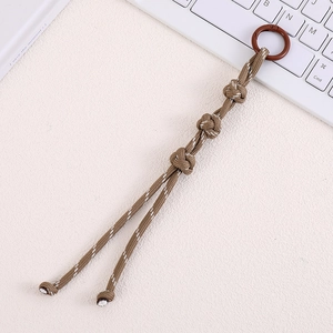 Detail of coffee-colored hand-woven Chinese knot bag pendant with white stitch texture