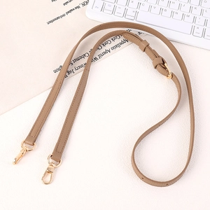 Detail of adjustable brown leather strap with polished golden metal buckles and stitching