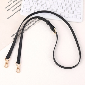 Detail of black litchi grain leather strap with adjustable gold buckles and swivel clips